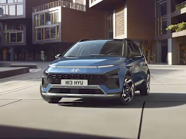 Hyundai BAYON car in blue parked in front of a modern building