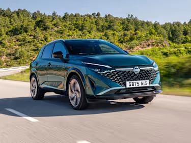 Nissan Qashqai e-Power car driving down a country road surrounded by trees