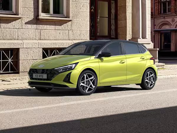 Hyundai i20 car in lime green parked in front of a classic building