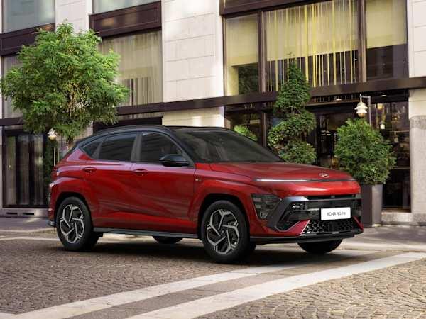Hyundai KONA car in red parked in front of a modern building