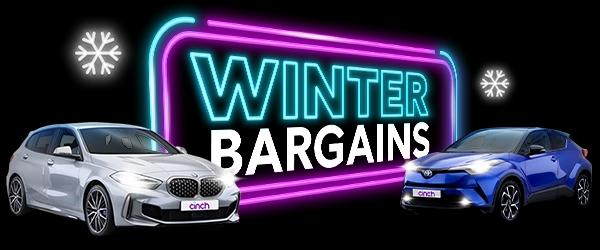 Neon 'Winter bargains' sign with two cinch cars either side