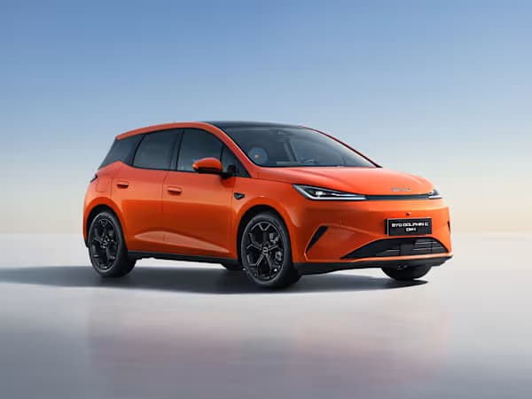 A BYD Dolphin G electric vehicle in a striking orange colour, parked on an abstract plane with the sky behind